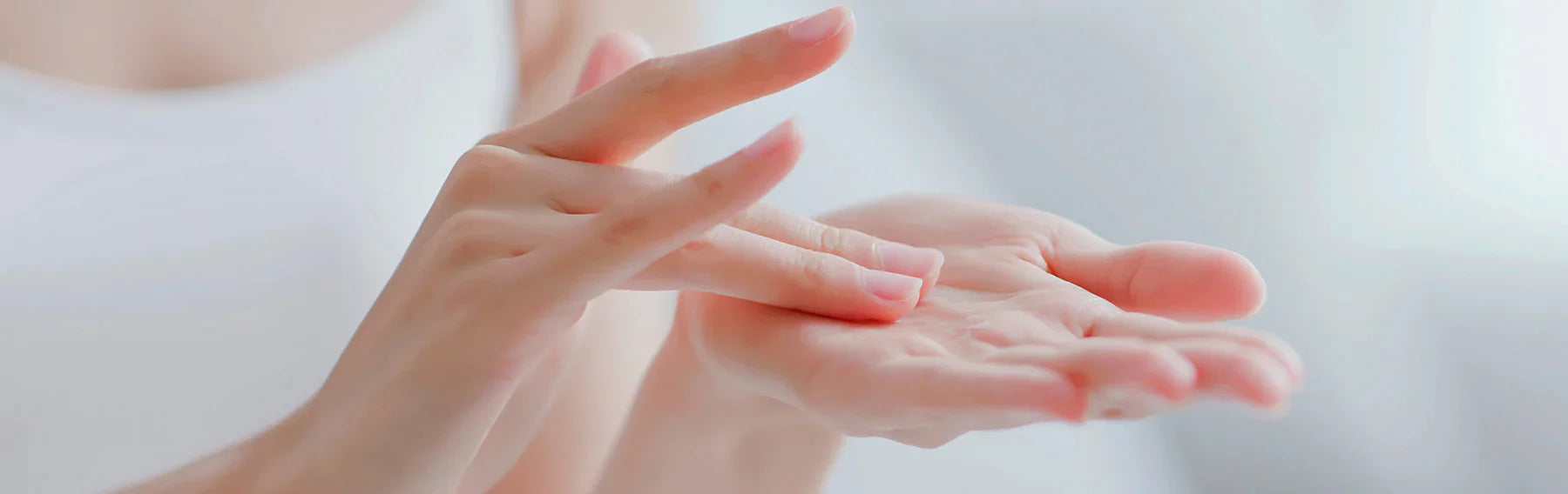Close up of the hands of a person wearing a white shirt